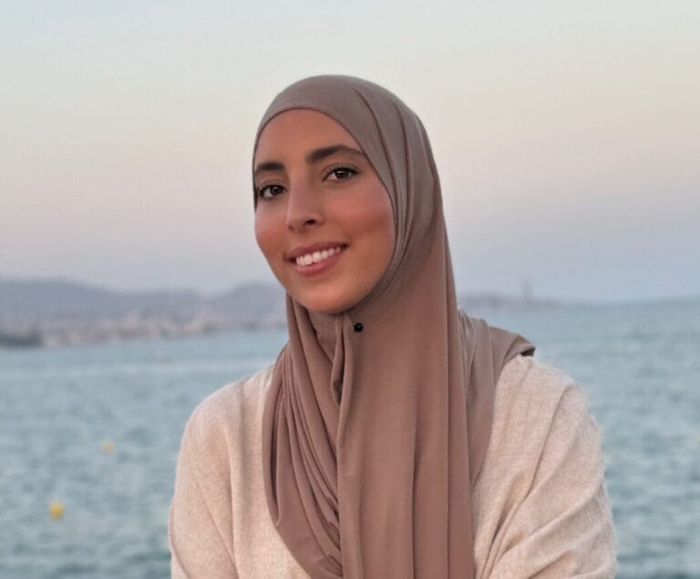 Psycholoog Zahra (Salhi) die lacht naar de camera met de zee in de achtergrond